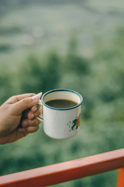 someone holding a coffee cup with a view