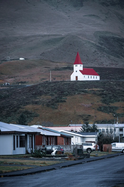 a street with multiple houses in it, and an odd looking church near by