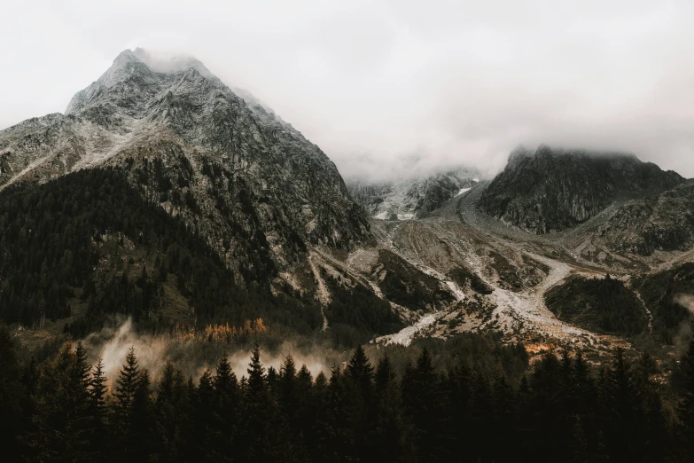 a tall snow covered mountain sitting under clouds