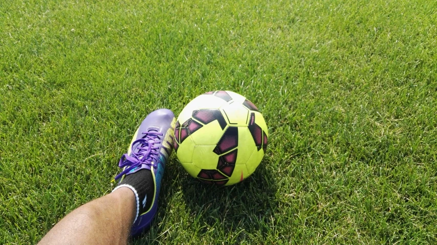 a man holding onto a soccer ball on a field