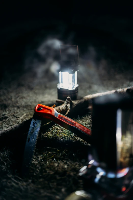 a flashlight, an orange handled pliers, and a knife on the ground