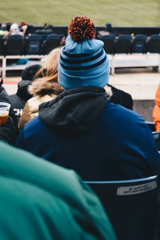 people with hats are sitting around in a stadium