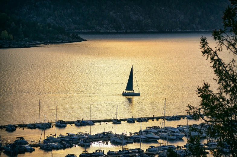 a large body of water with a sail boat in the distance