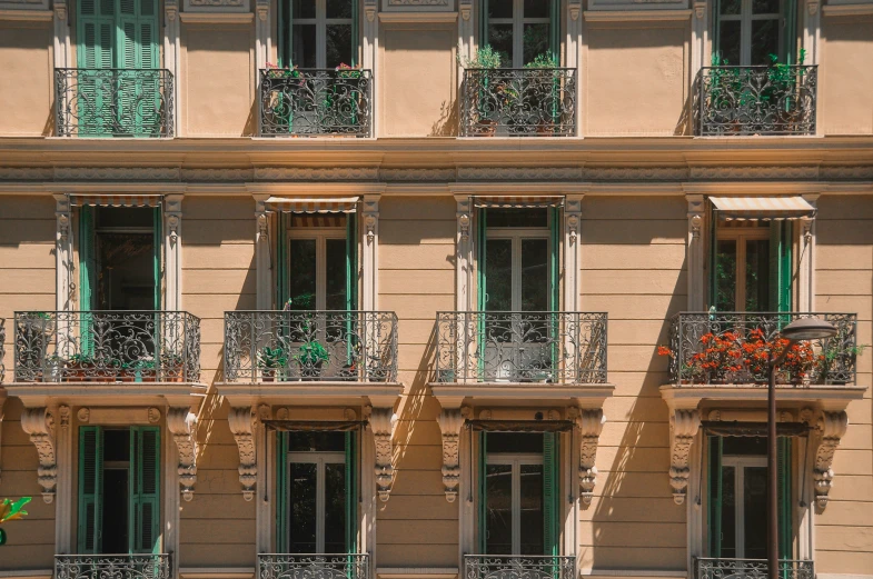 a tall building with lots of windows and green shutters