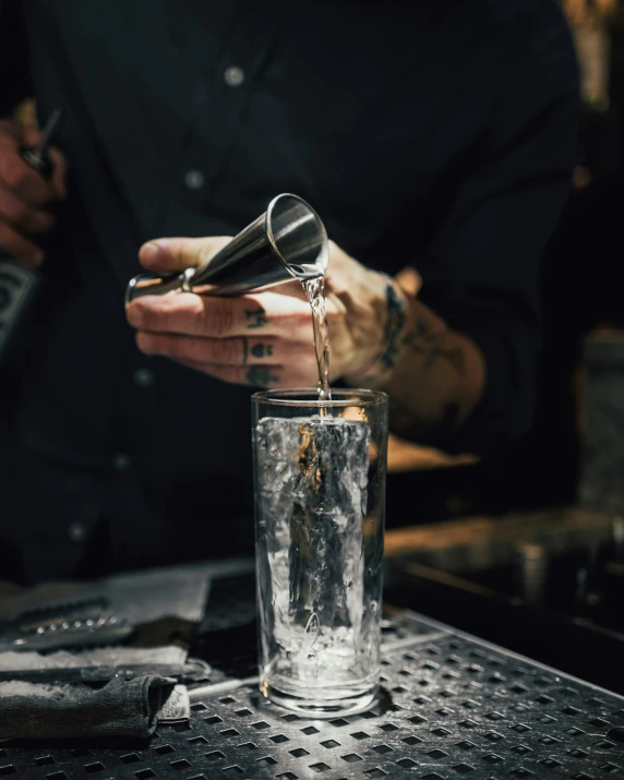 a man is preparing a drink in a glass