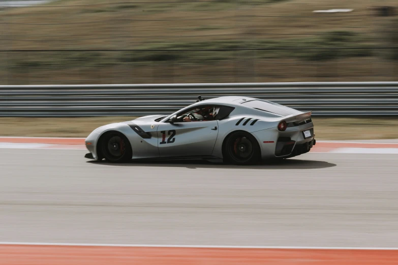 a large sports car driving down the track