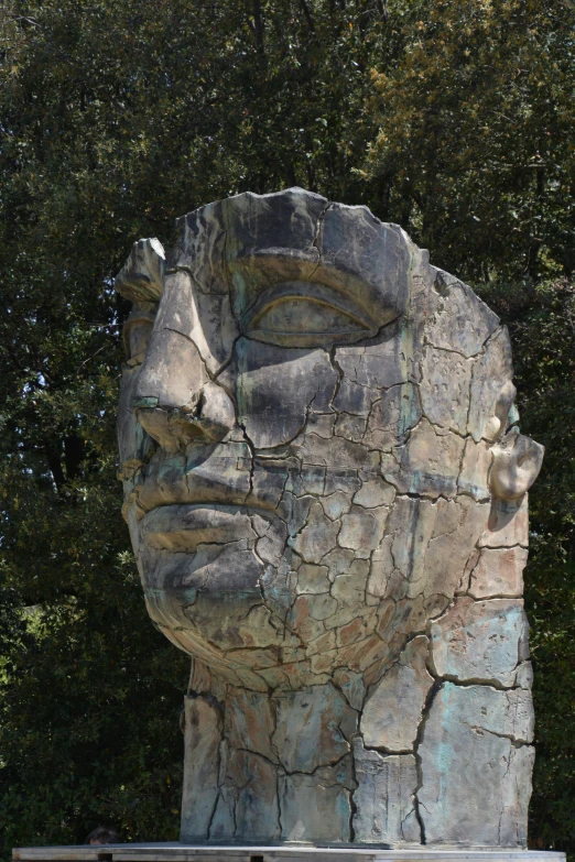 an artistic statue made of stone on a wooden platform