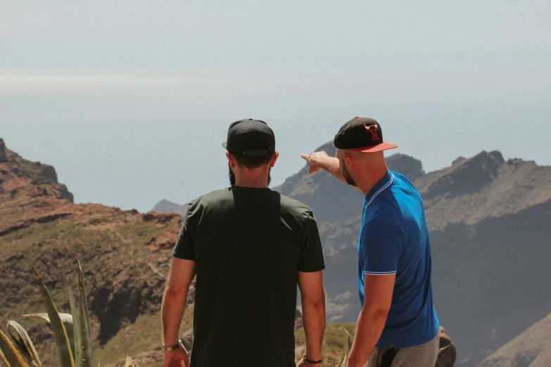 two men are standing on top of a mountain