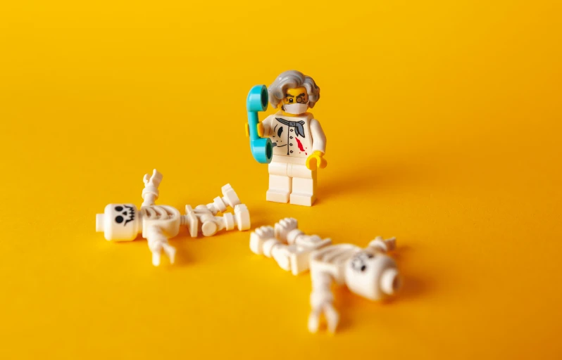 lego figure in white outfit with toy horses and cows on yellow background