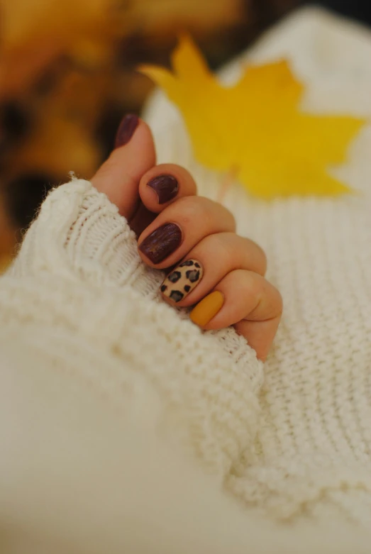 a woman with some nail polish is holding up her hand