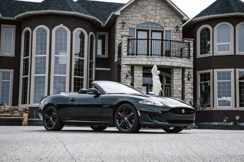 a car parked outside a brown house in front of a tall building