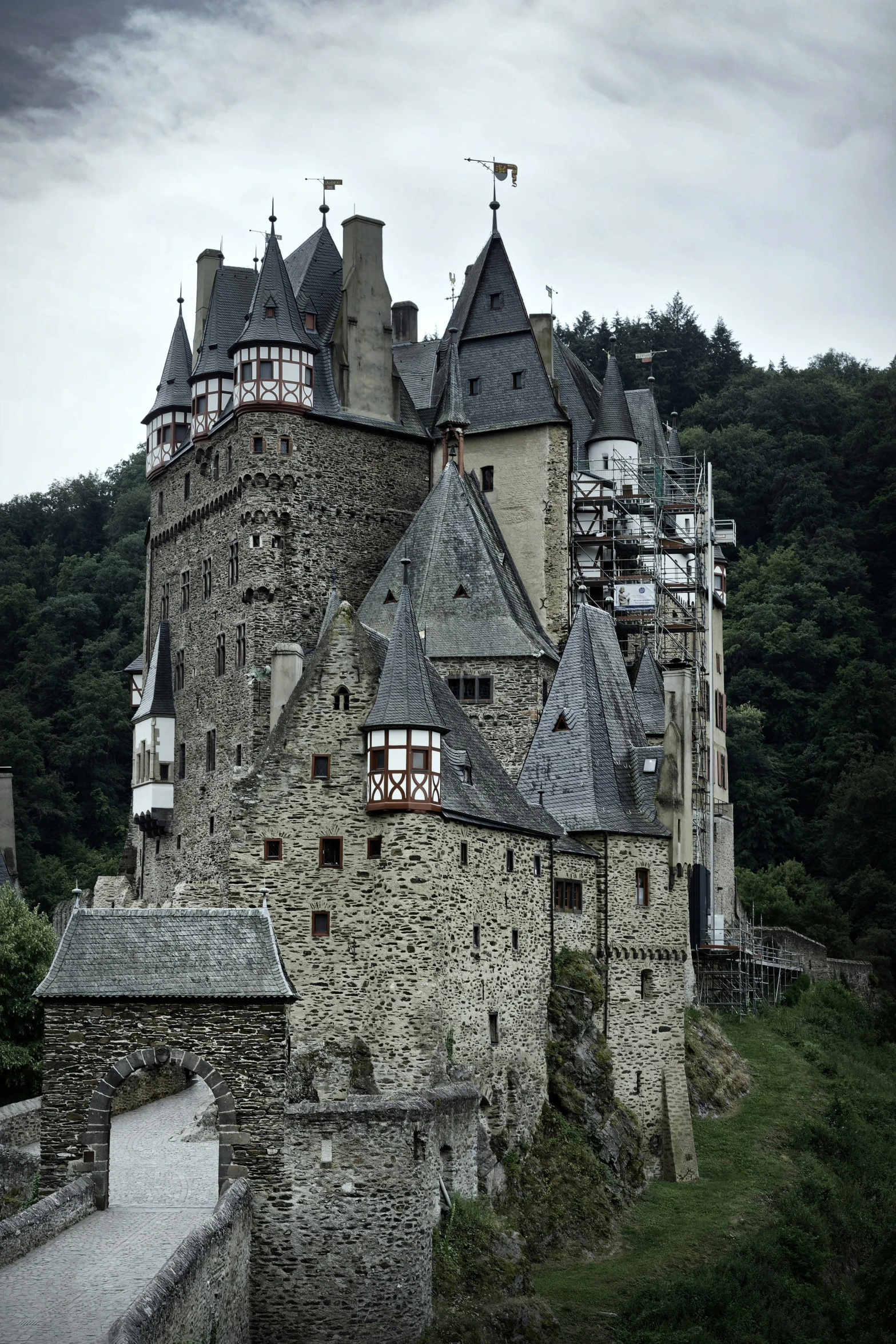 an old building on a hill with mountains in the background