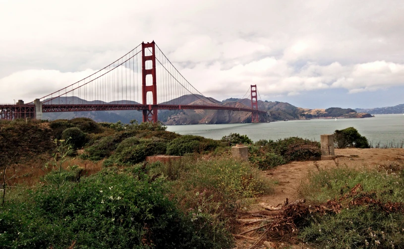 a very nice bridge in the background of some hills and water