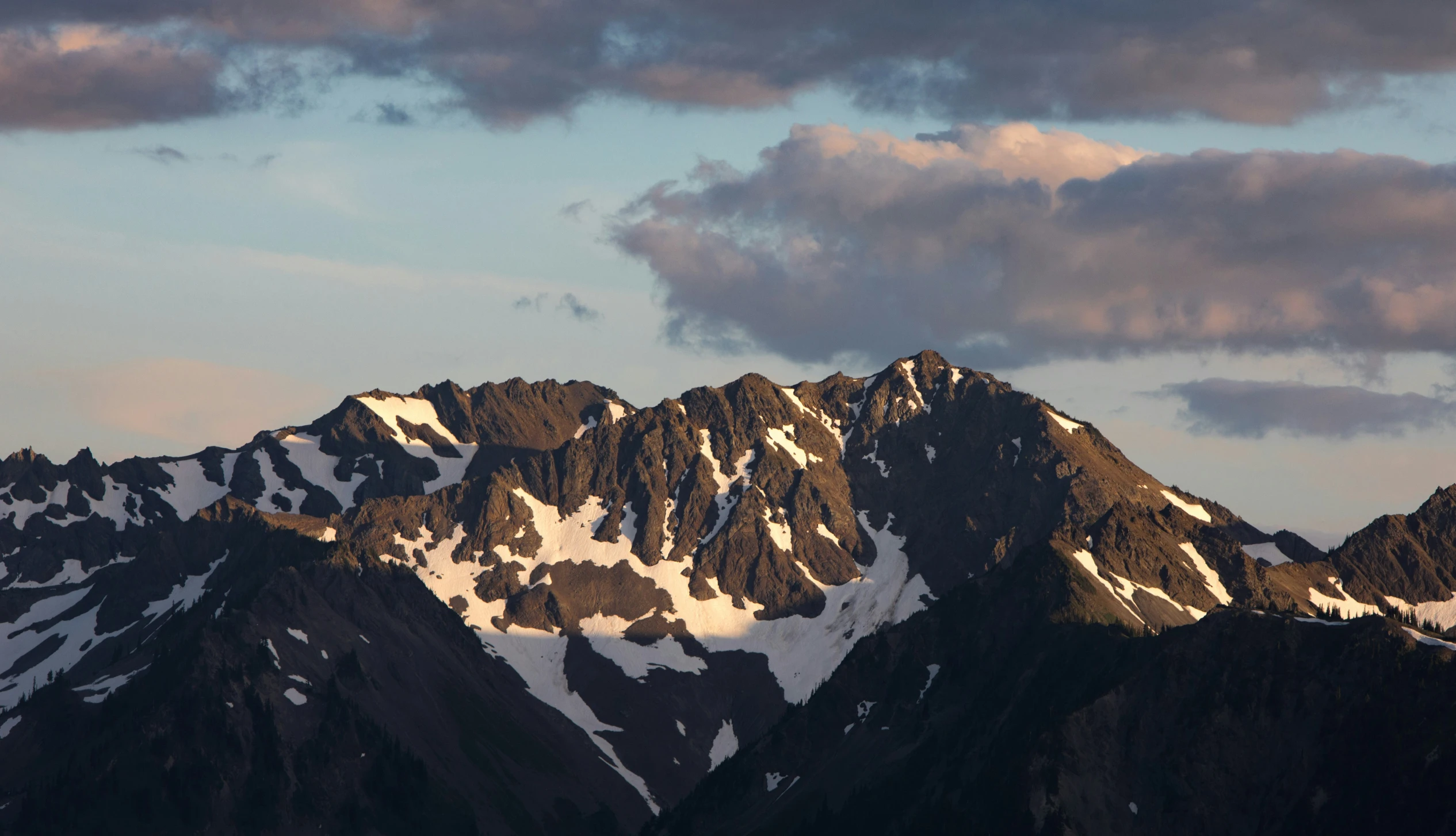 there are mountains under a cloudy sky