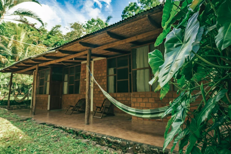 a small building with a porch and a hammock on the front