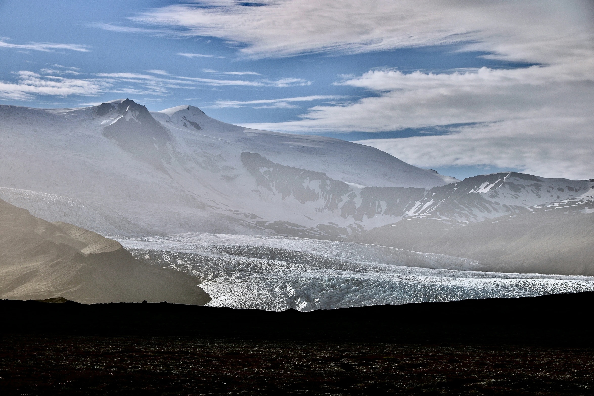 snow covered mountains in a remote area under clouds