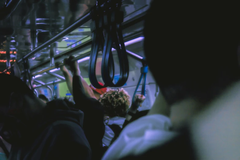 a crowd of people riding on the bus at night