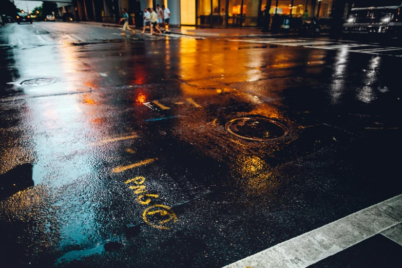 a wet city street in the middle of a crosswalk