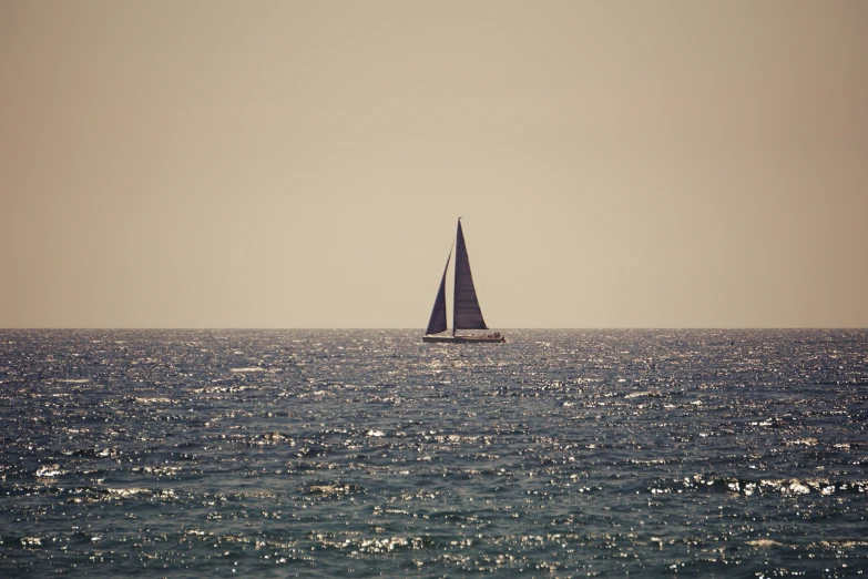 the sailboat is seen sailing across the blue ocean