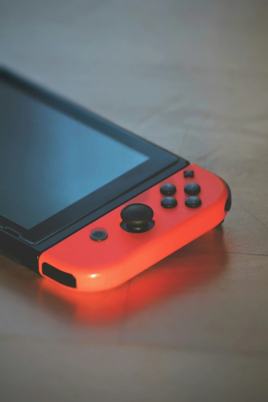 a handheld game console that is lit orange and black