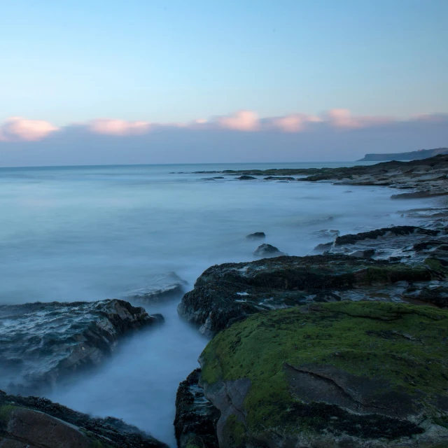 a blue ocean that has some rocks in it