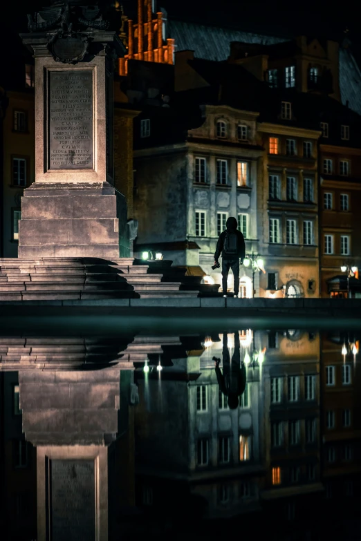 a man standing by a fountain at night