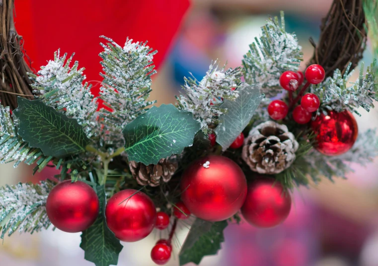 a wreath has pine cones and evergreens on it