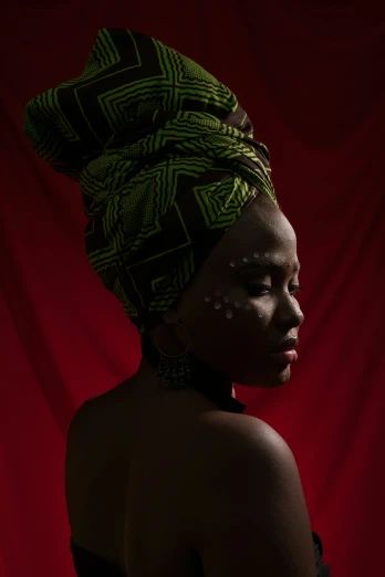 the beautiful black woman wears an unusual green head wrap