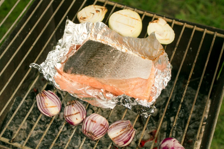 some meat and garlic are being cooked on the grill