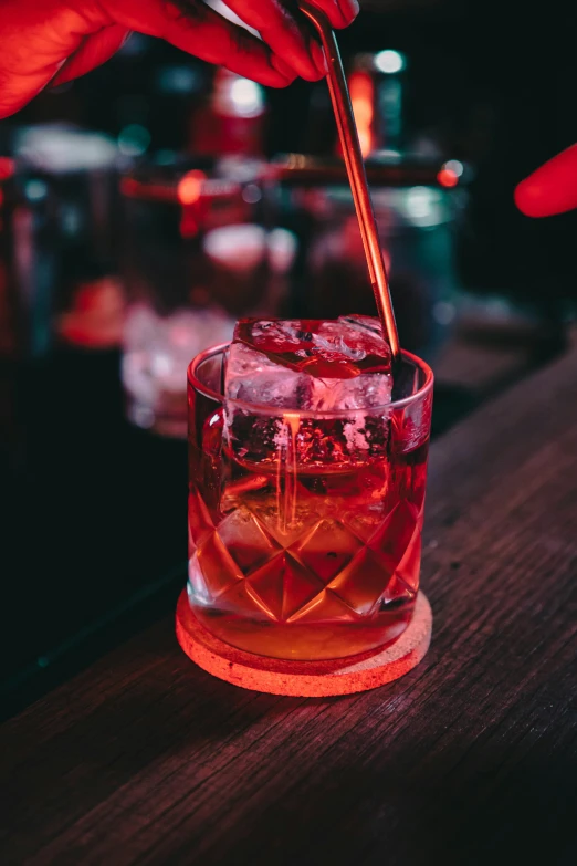 someone is pouring a drink in a tall glass