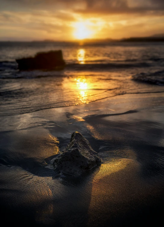 a beach at sunrise with waves coming in