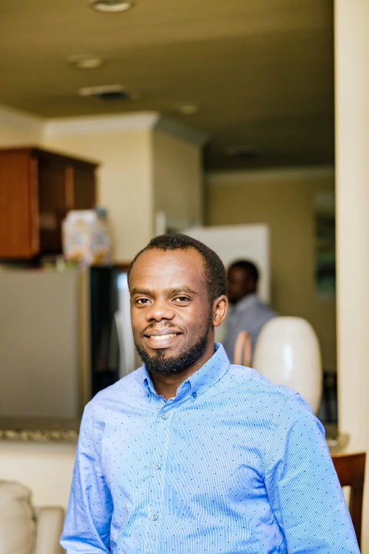 a man smiling, in his home in the background