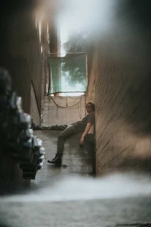 a man is sitting on the ledge of a stairwell