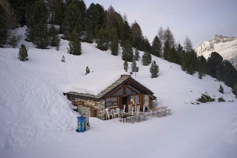 a small cabin sits on the side of a mountain