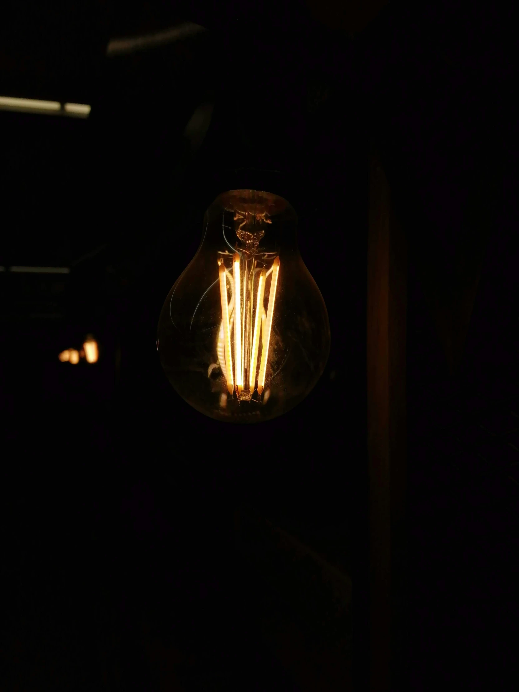 a lit light bulb is hanging down and glowing