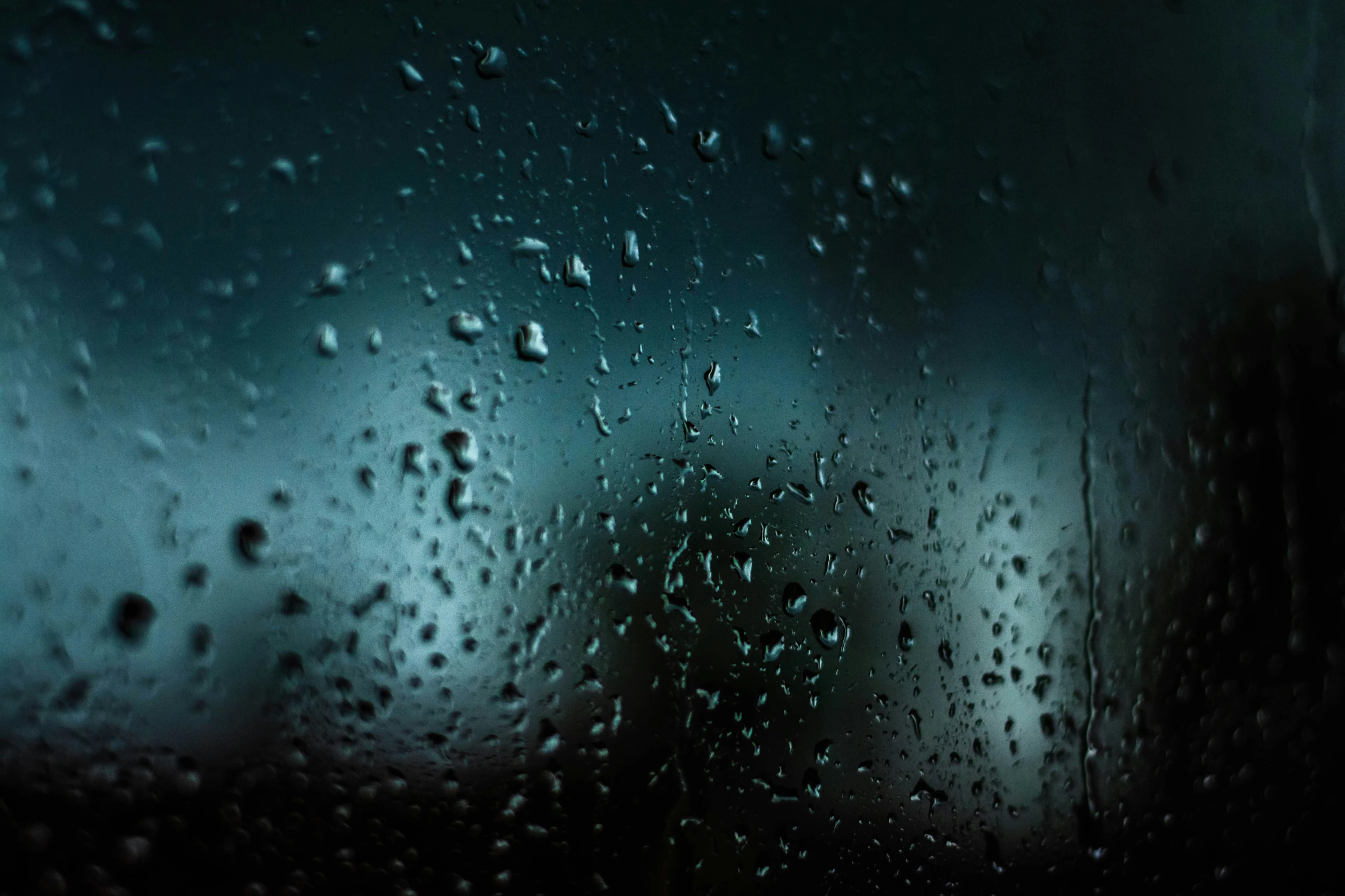 a rain covered window with rain drops on it