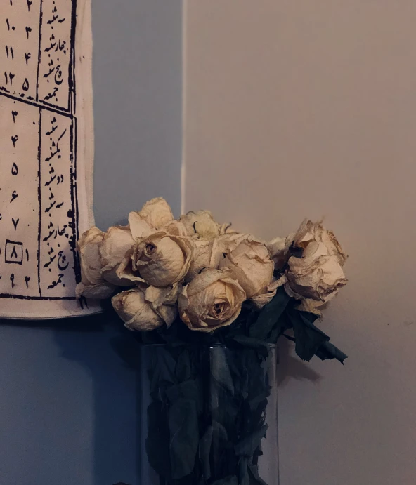 a bouquet of roses sits on the counter of a bathroom