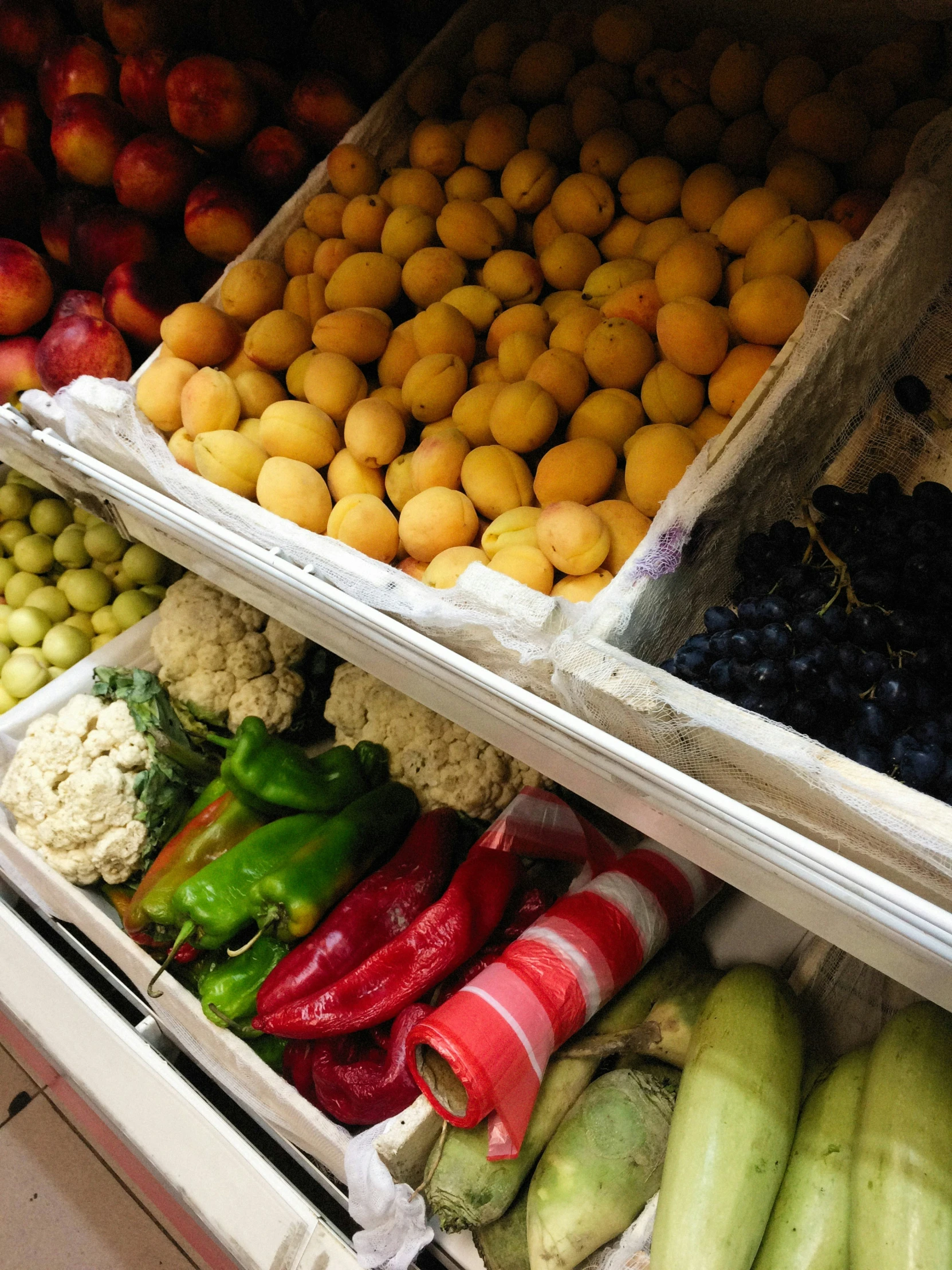 fruit and vegetables on display in bins at a market