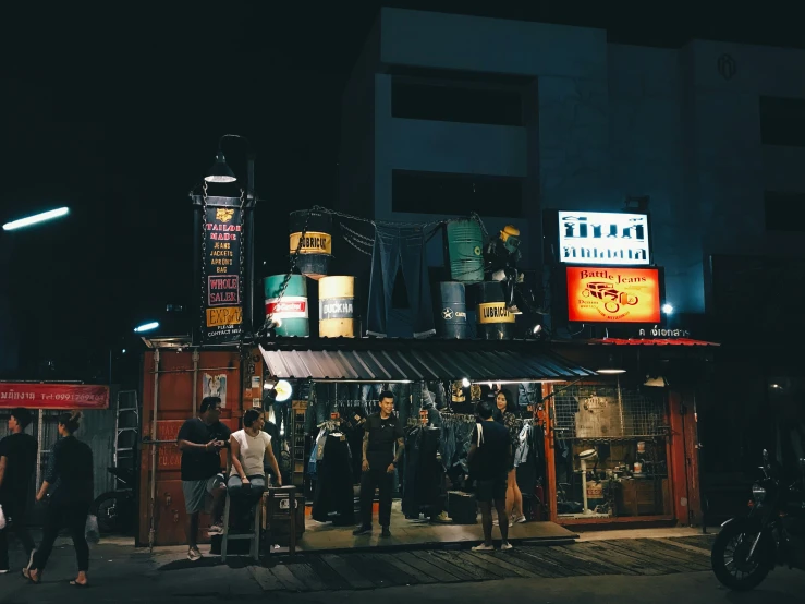 several people waiting outside a store at night