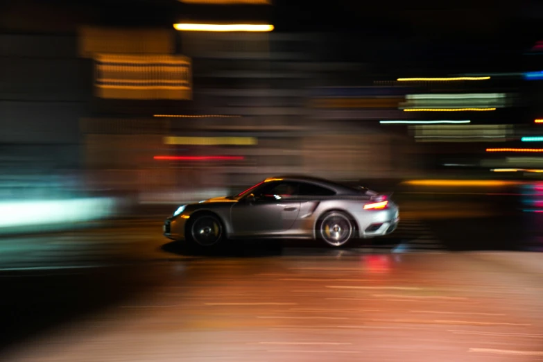 a speeding car on a city street at night