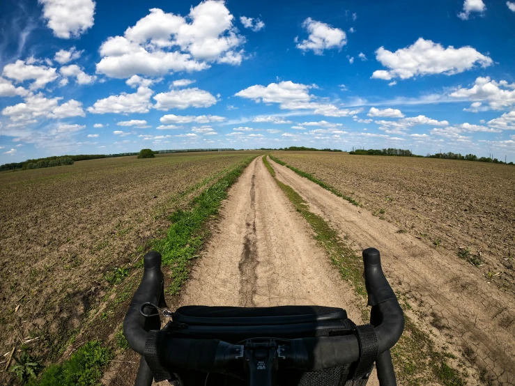 someone riding their bike in a field with no cars on the road