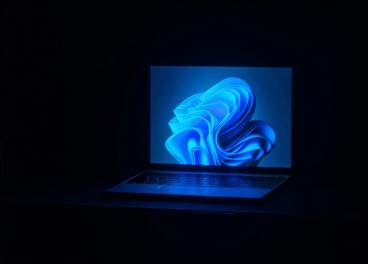 a close up of a laptop computer in a dark room