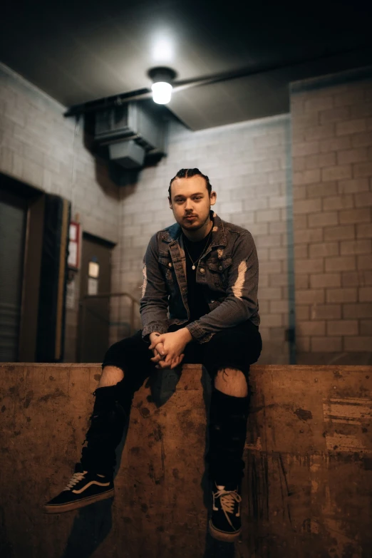 a man with tattoos sitting on top of a wooden bench