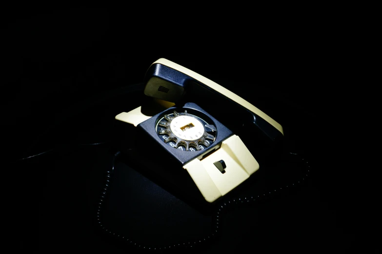 an old - style telephone sits in a black background