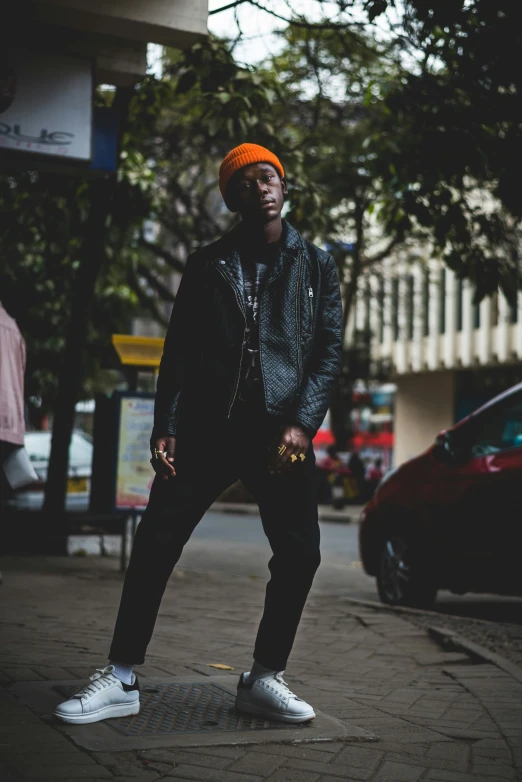 a man with a bright red mohawk stands on the sidewalk