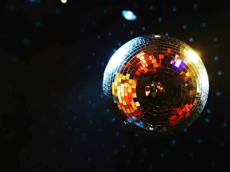 colorful circular mosaic disco ball floating in the night sky