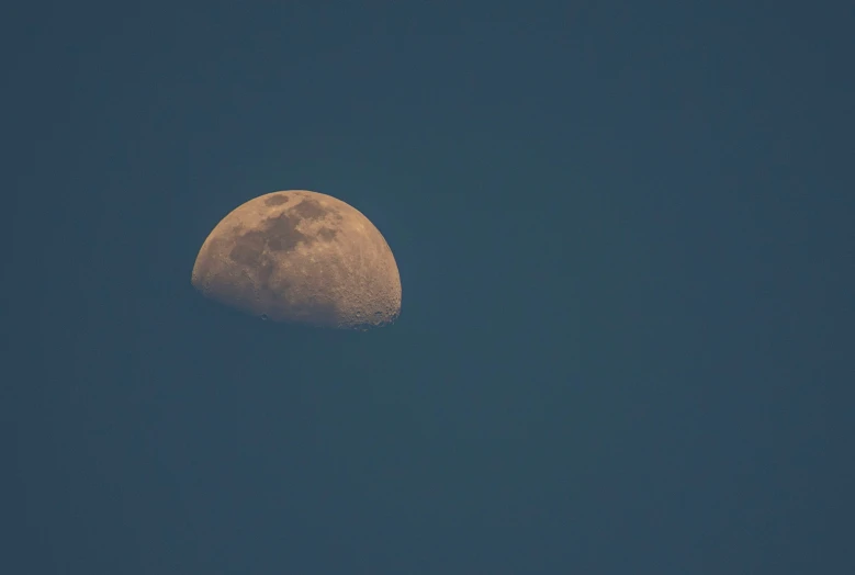 a half moon on the sky with no clouds