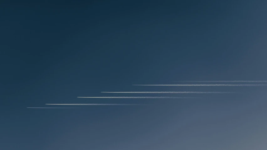 four airplanes are flying through a bright blue sky