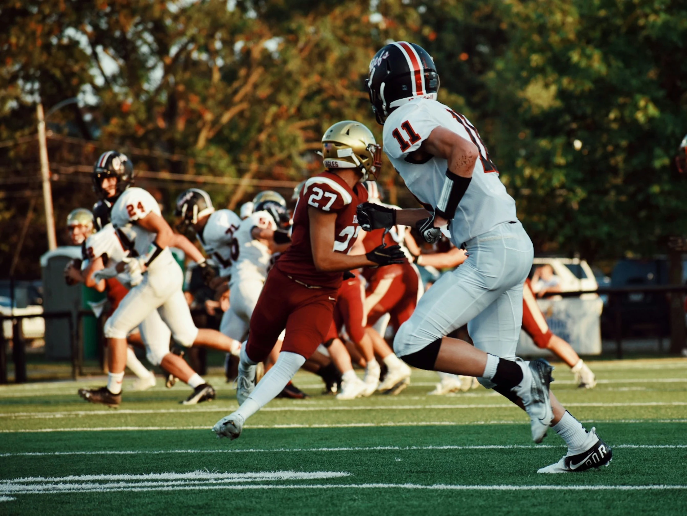 a football player runs towards the ball as other players look on