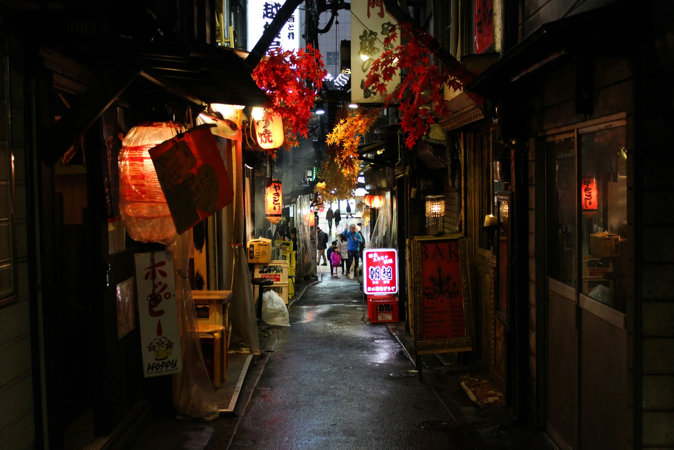 a narrow street in an oriental city with lanterns overhead